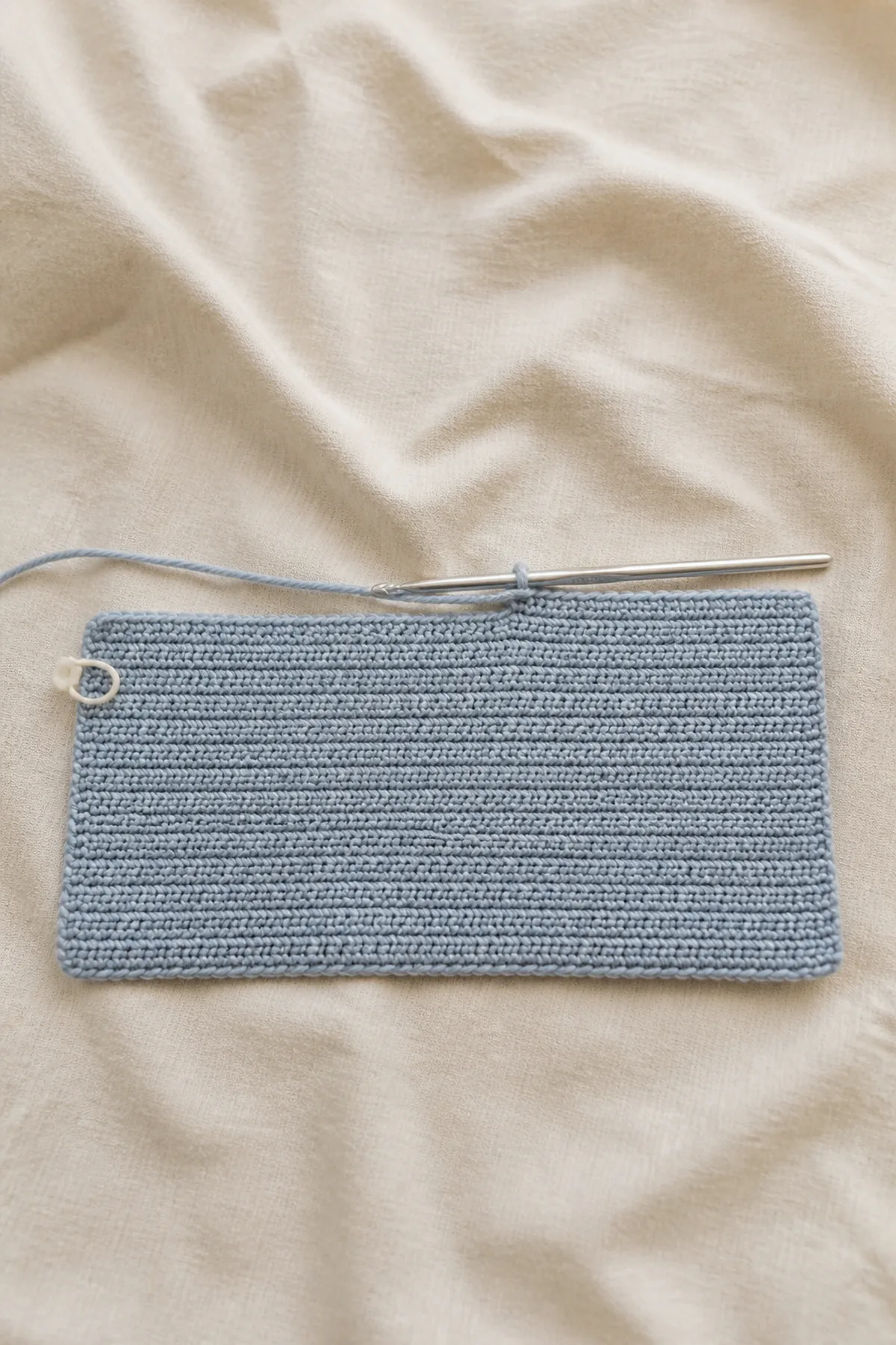Early counted crochet stage of sleepy baggy lovey with matching yarn and hook