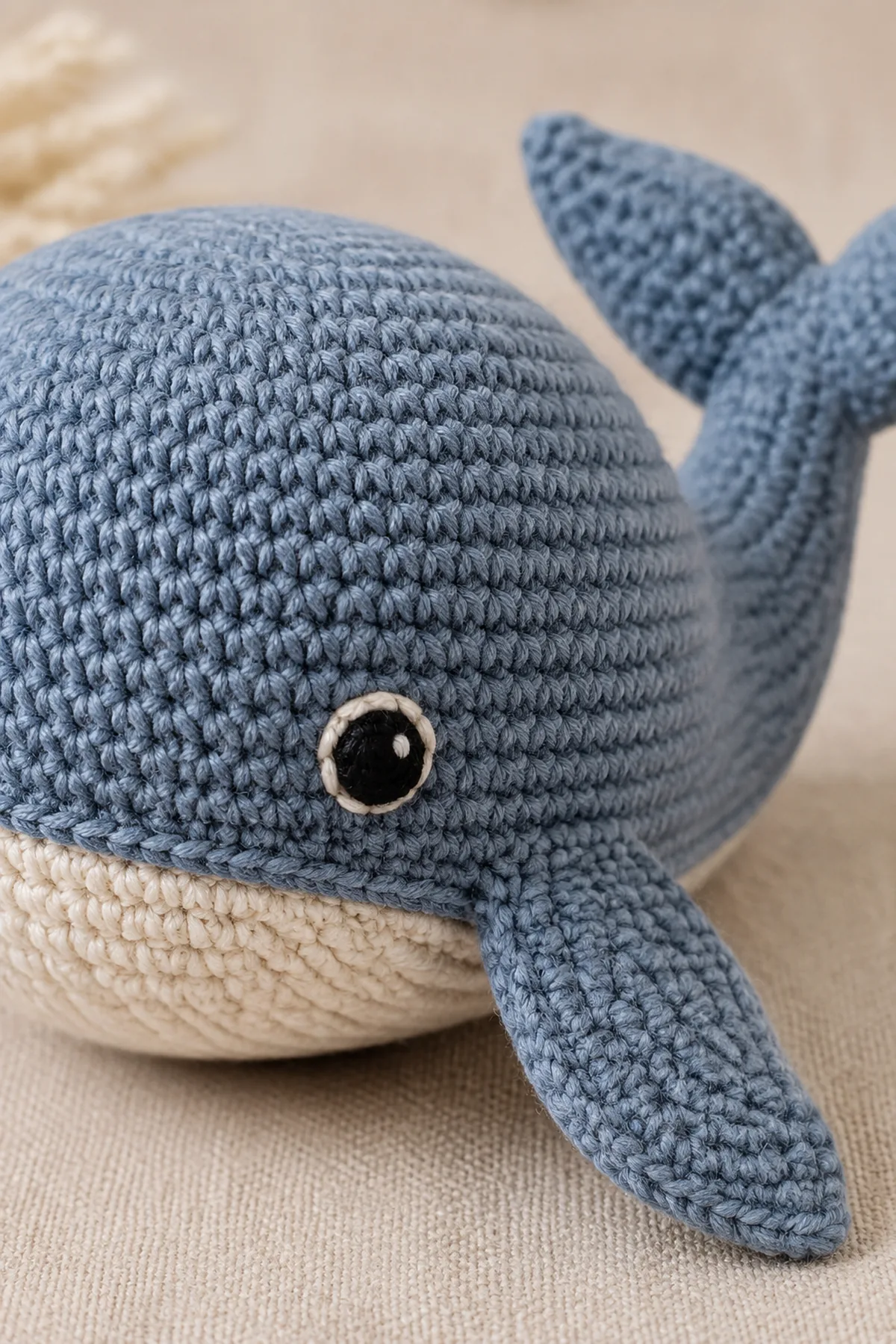 Close-up of the stitch texture and securely finished details on crochet whale soft toy pattern