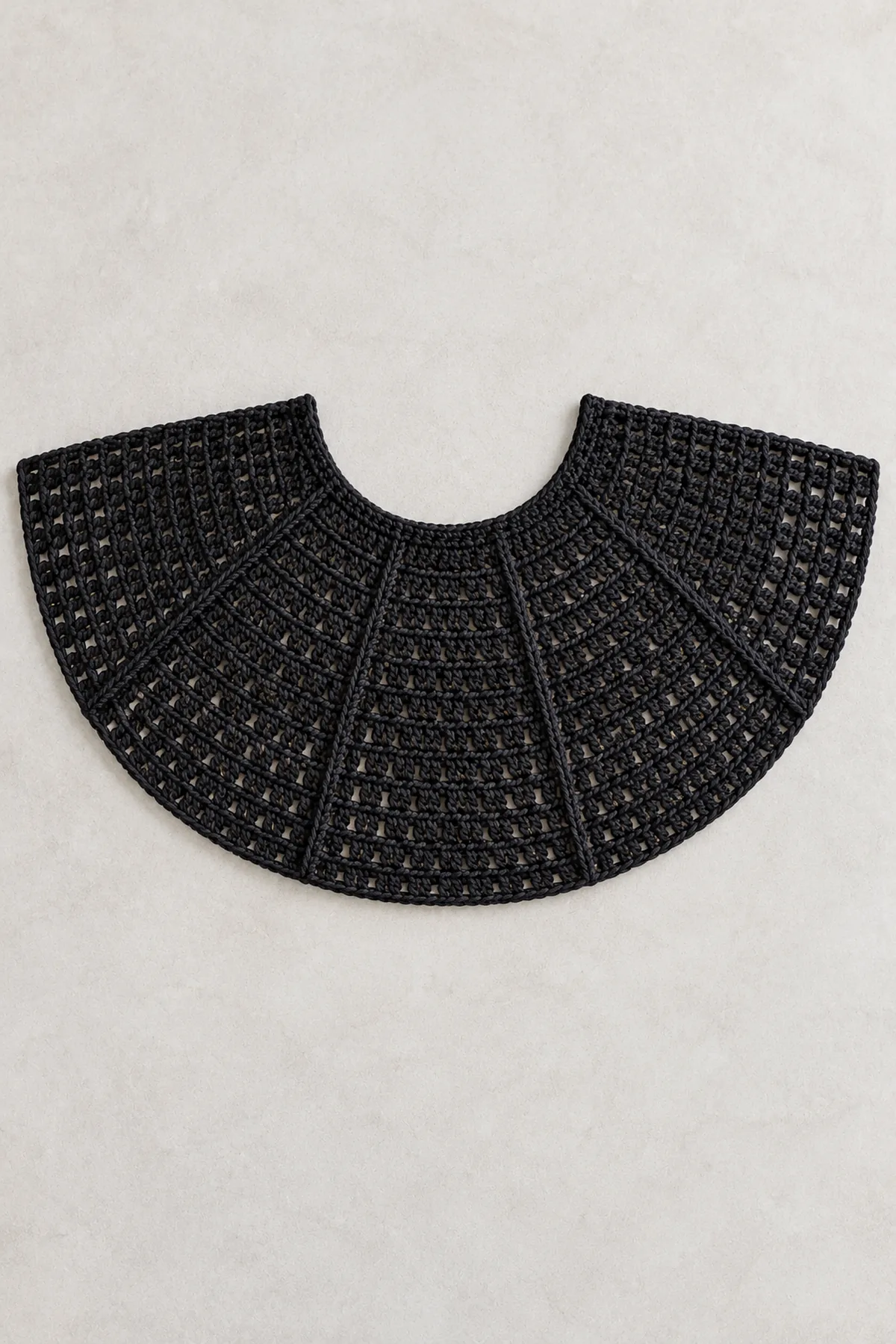 Black crochet cape body laid flat as a growing semicircle from curved neckline, six visible marker sectors, no wing points yet