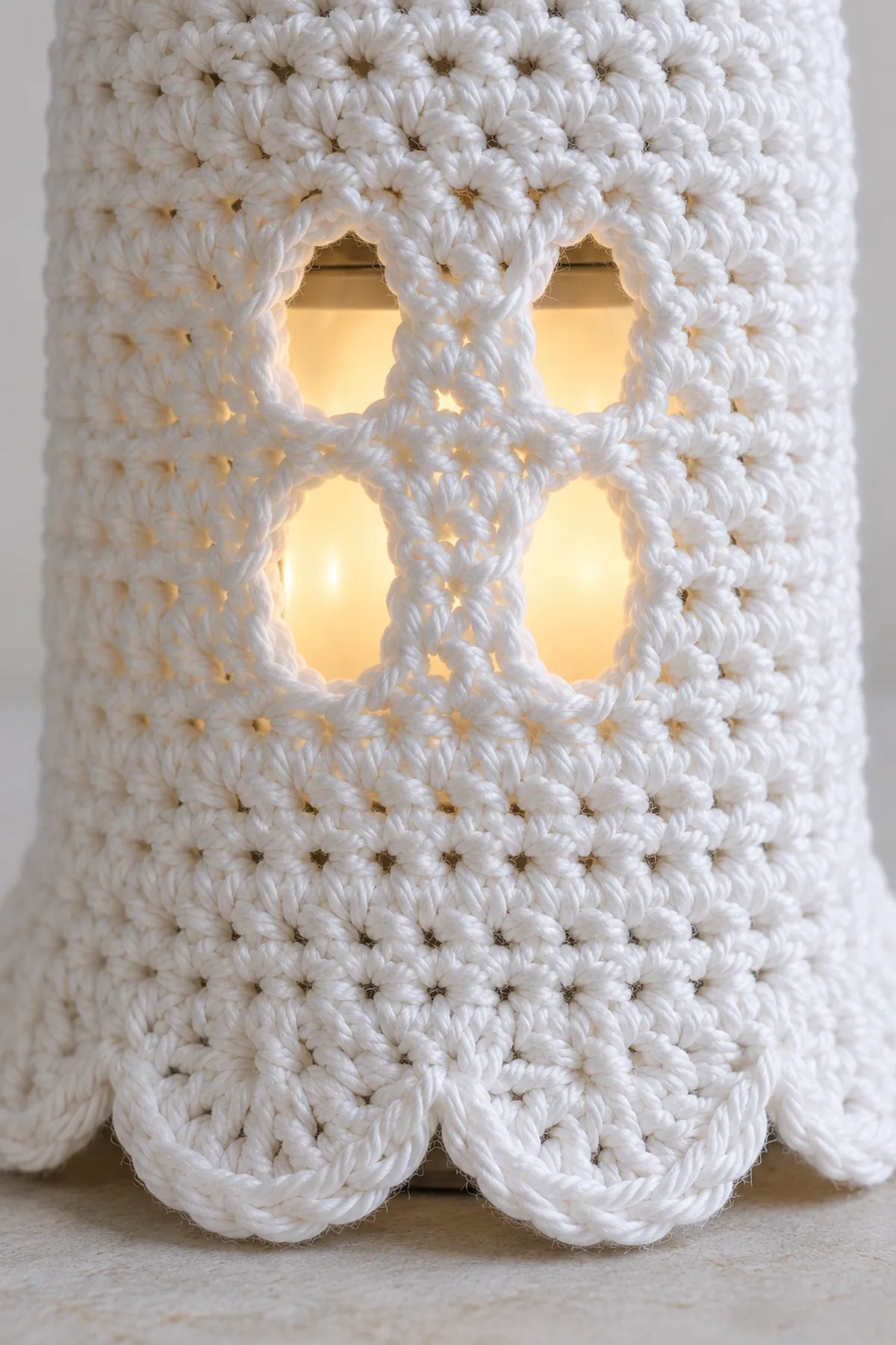 Macro of crocheted chain-bridge ghost eye holes and six-loop scallop repeat in white cotton, showing no sewn or glued face