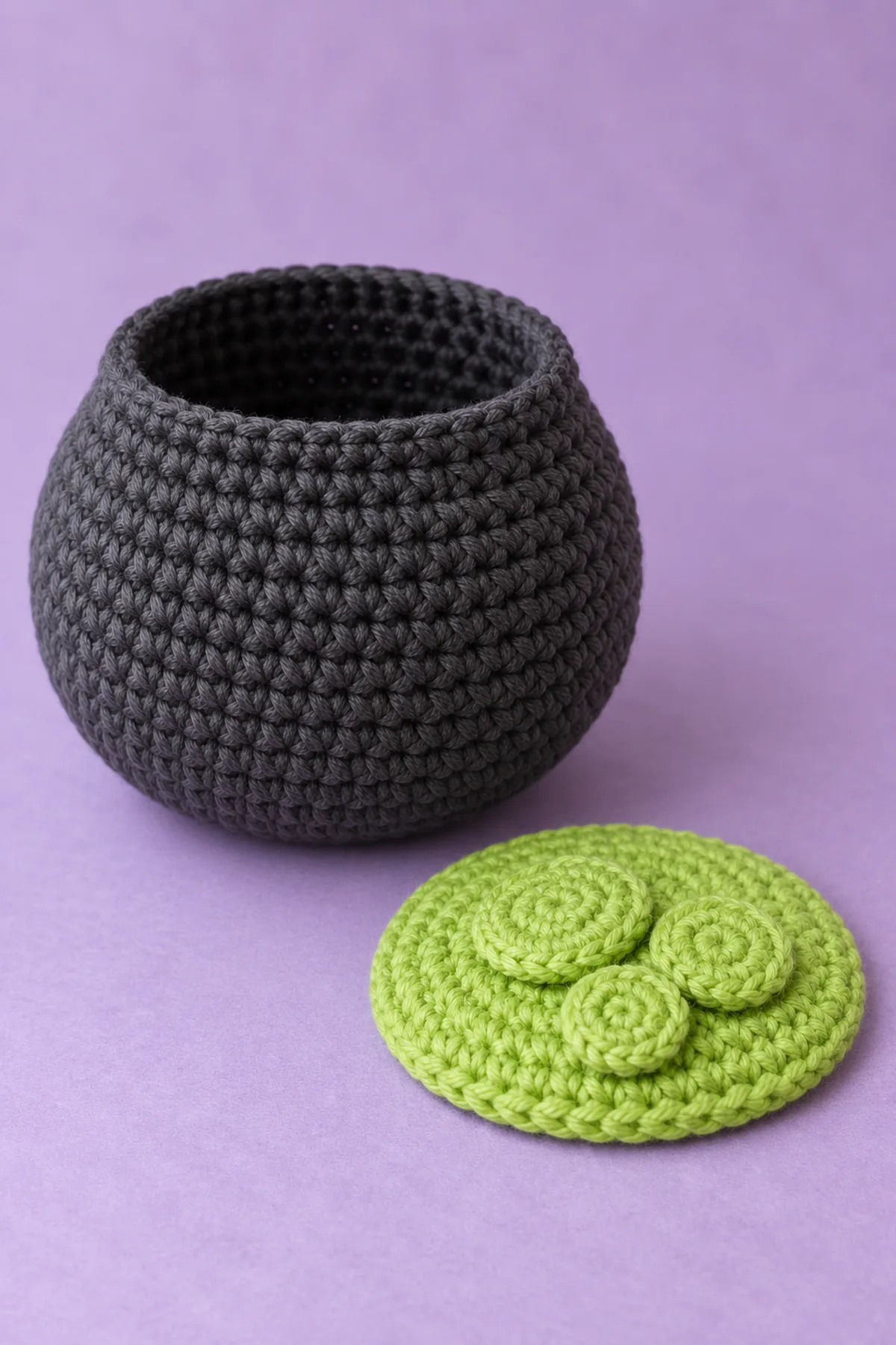 Charcoal stuffed cauldron body with open top, separate flat lime circular closure disc with three small flat overlapping lime bubble discs sewn on it, pieces laid beside each other before top seam. No rolled rim or handles yet