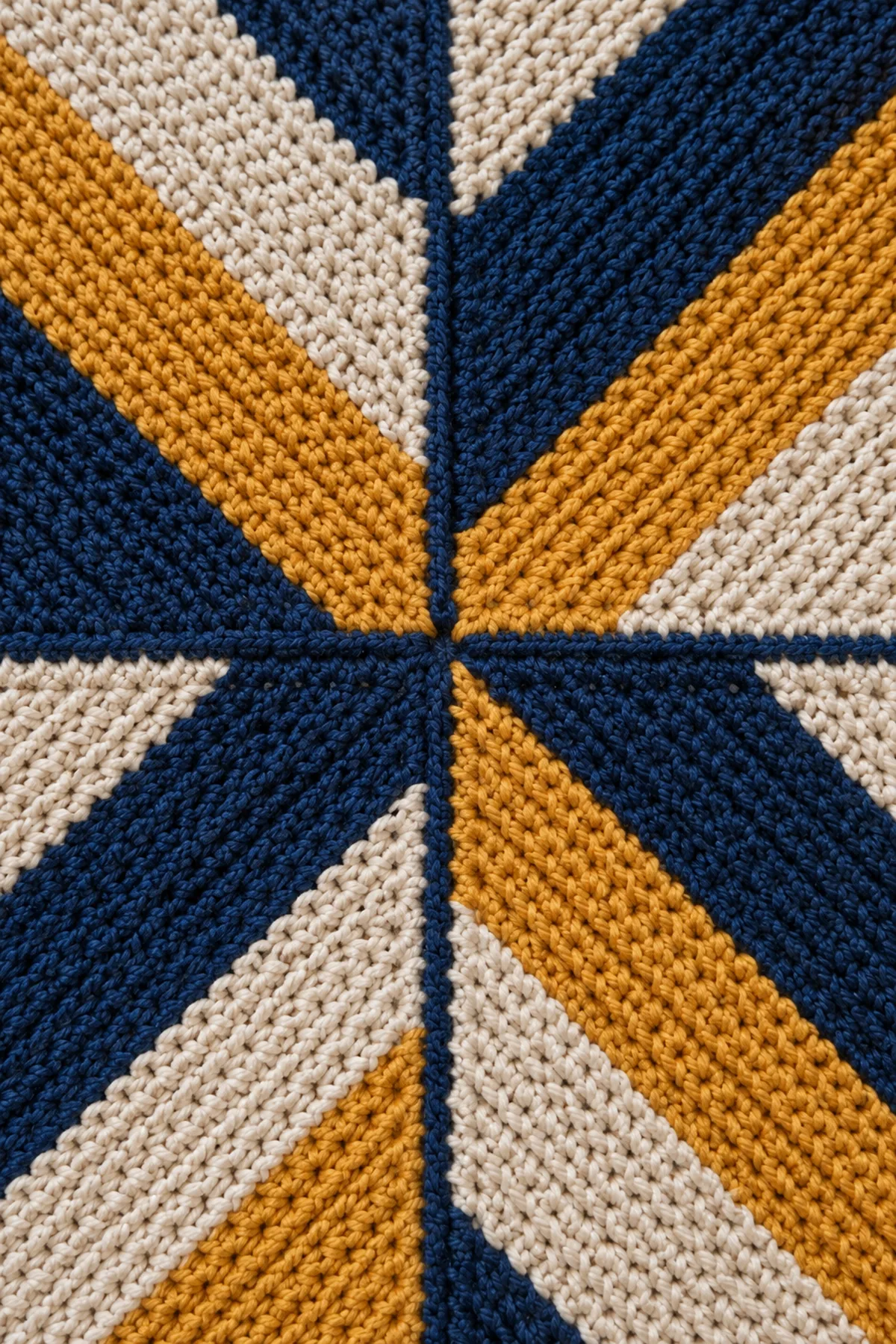 Close view of one centered single-crochet three-together miter and clean mattress seams where navy oat and ochre panels meet
