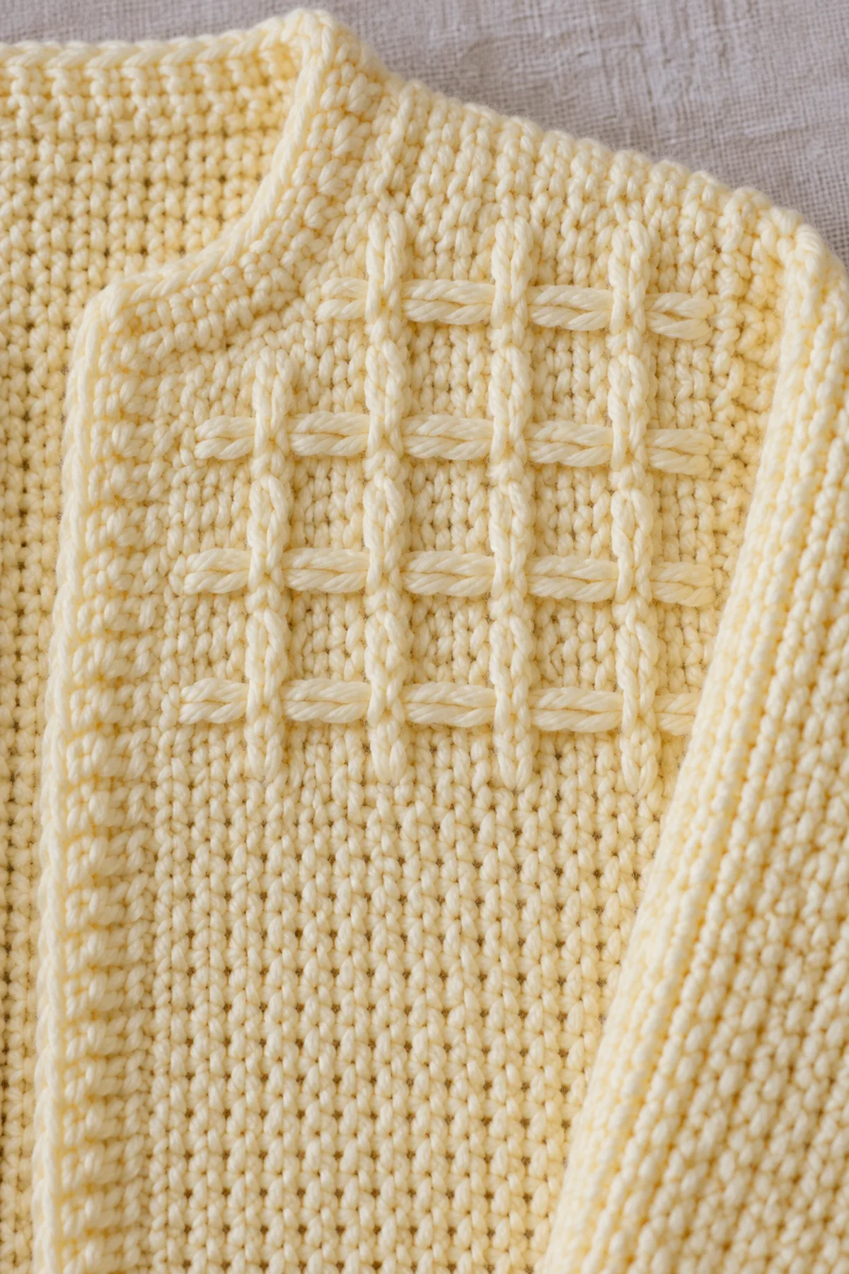 Macro of tiny enclosed same-color horizontal smock-effect bars over buttercream Tunisian simple-stitch columns, flat ungathered fabric and no loose floats