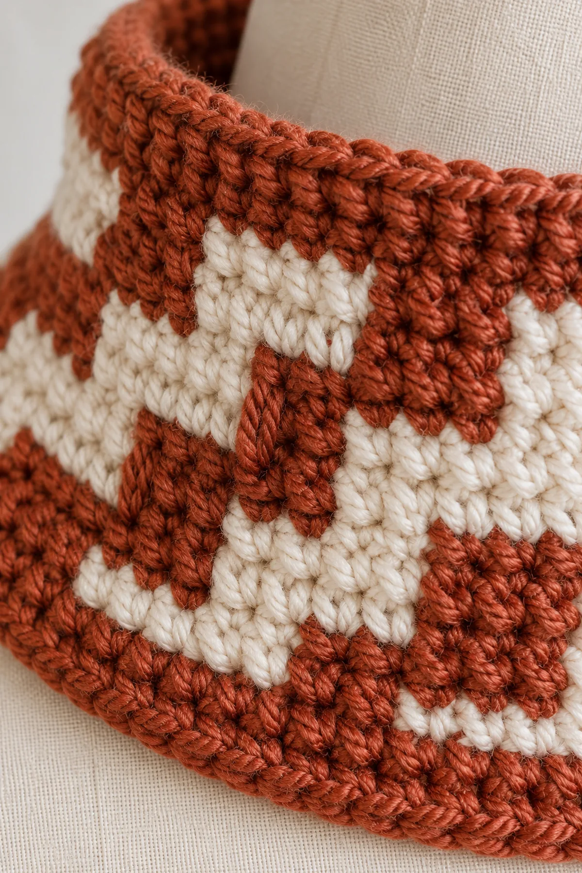 Close macro of rust-and-cream crochet overlay mosaic showing one long front-loop double crochet bar two rows below beside back-loop single crochet and a plain flexible border