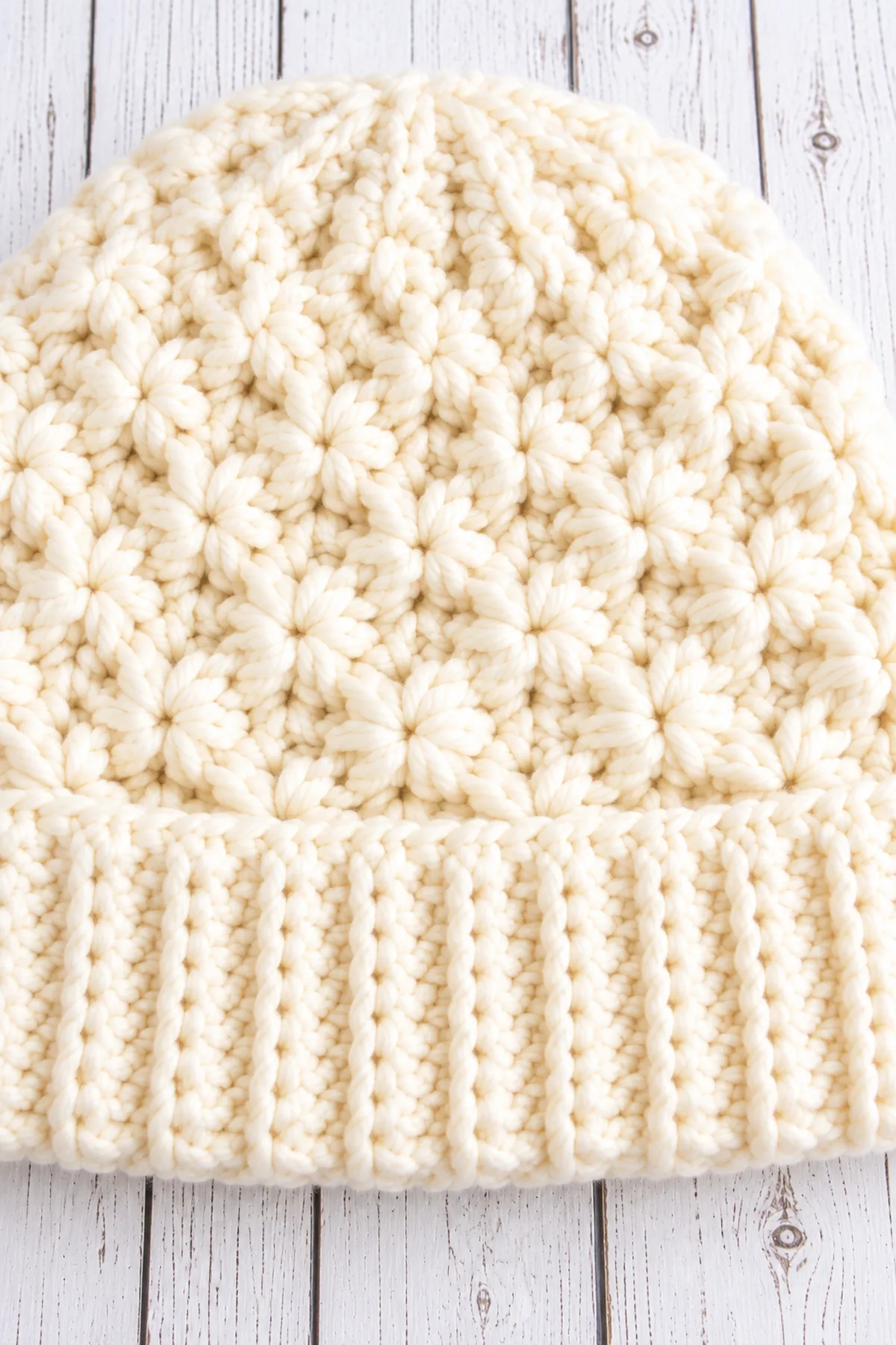 Macro of stretchy ribbed brim seam, compact star-cluster texture and evenly spaced crown decrease lines.