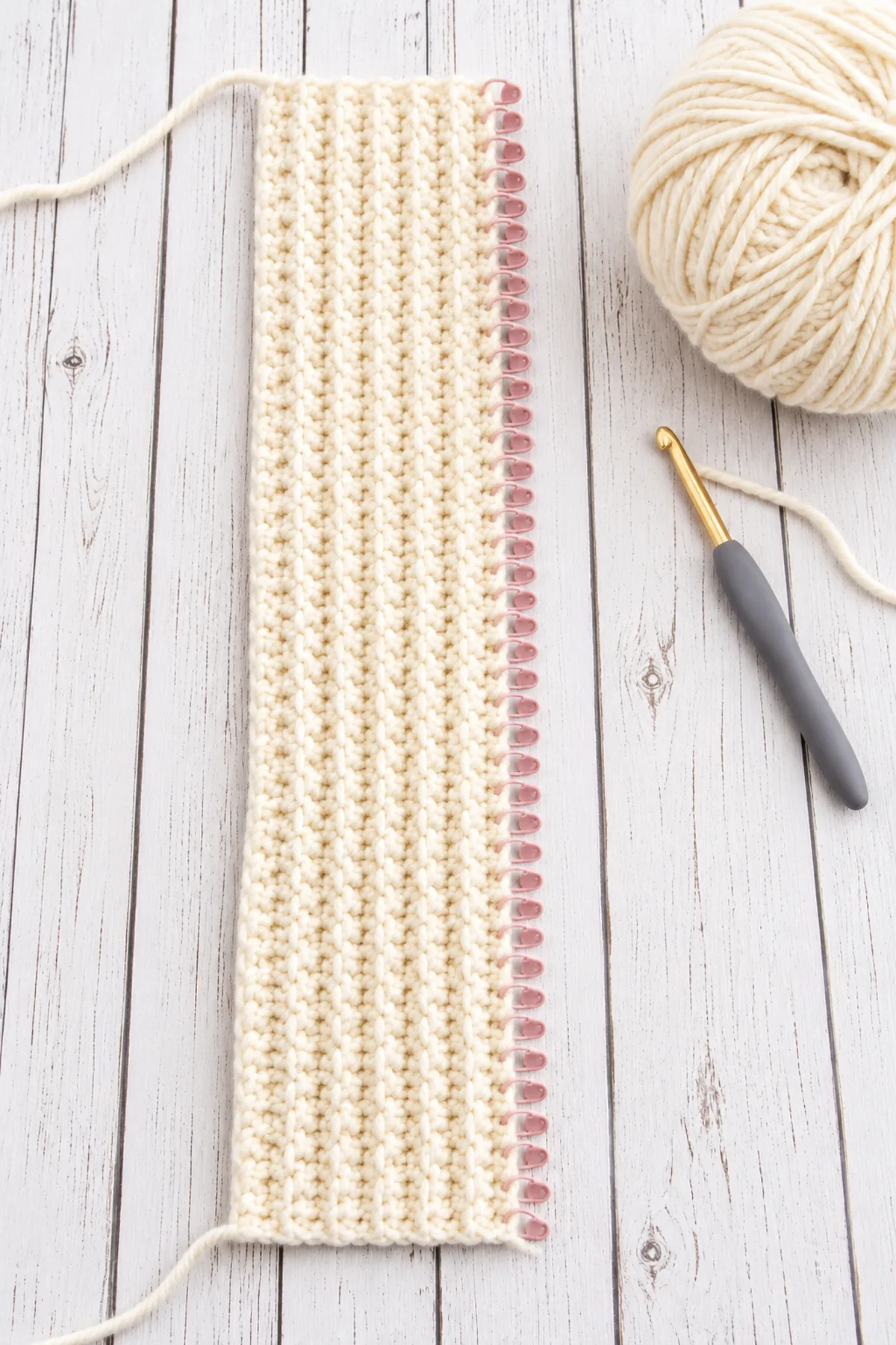 Long cream ten-stitch BLO ribbed strip with 54 marked row ends before joining into the beanie brim.