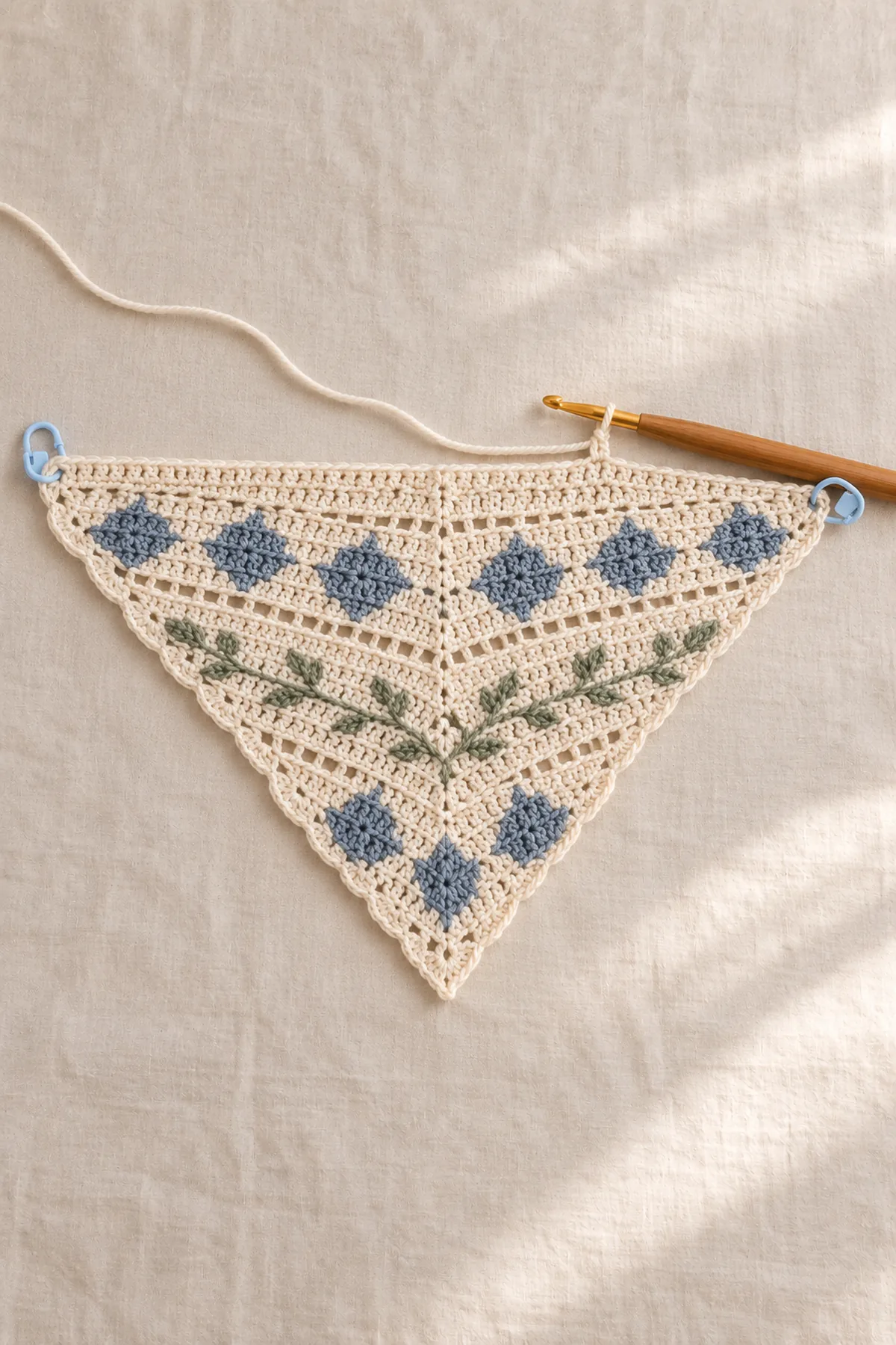 Early construction stage of nordic charted crochet triangle shawl with scalloped edge